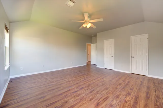 a view of an empty room with wooden floor
