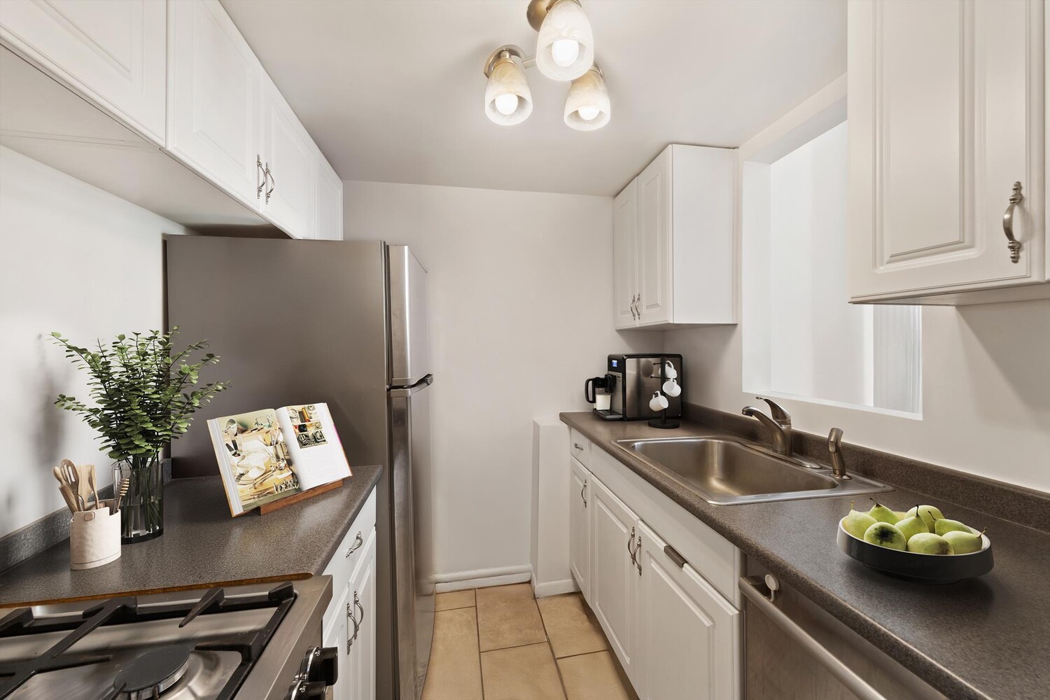 67 East 11th Street, Unit 503 Manhattan, NY 10003 - Photo 4 of 10 a kitchen with stainless steel appliances granite countertop a sink refrigerator stove and microwave