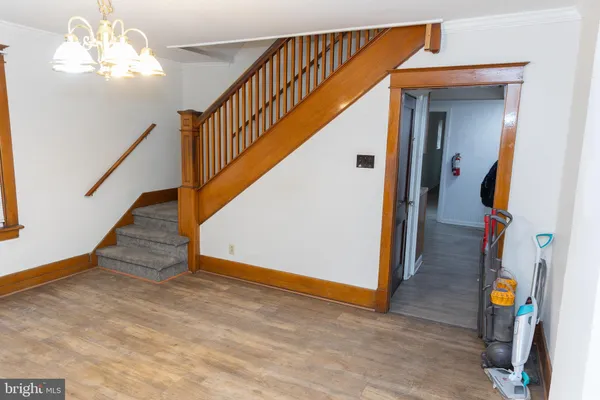 a view of a hallway with wooden floor and a bathroom