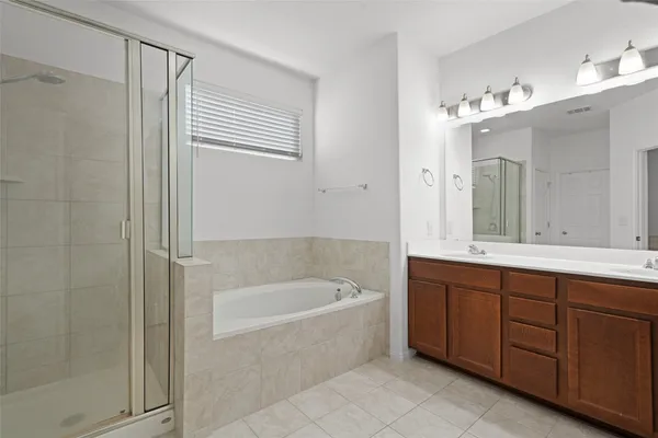 a spacious bathroom with a tub sink and mirror