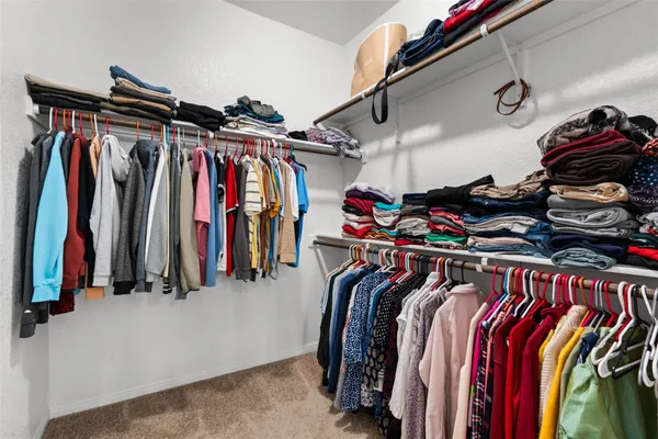 a view of walk in closet with clothes
