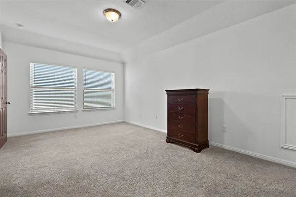 an empty room with windows and cabinet