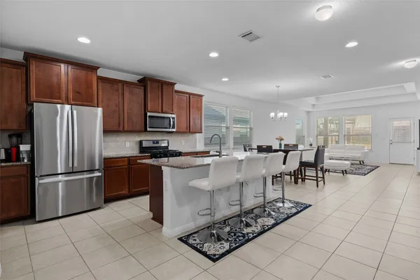 a kitchen with stainless steel appliances granite countertop a refrigerator and a stove top oven