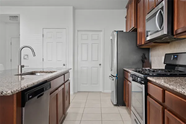 a kitchen with stainless steel appliances granite countertop a sink stove and refrigerator