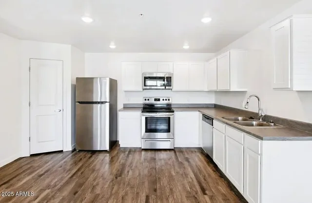 a kitchen with a refrigerator and a stove top oven