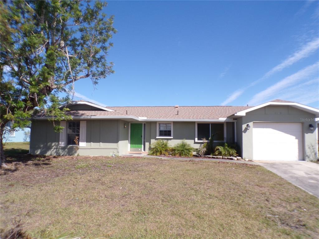 a front view of a house with a yard and a garage