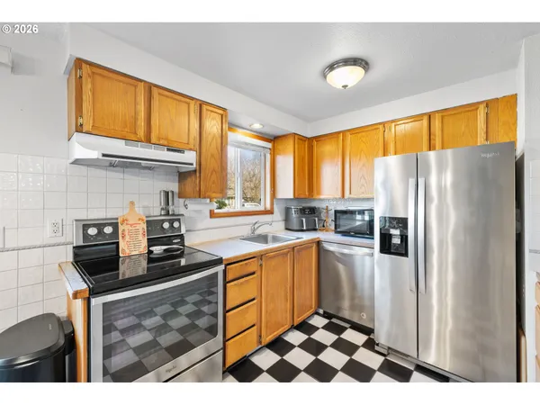 a kitchen with stainless steel appliances a stove a sink and a refrigerator