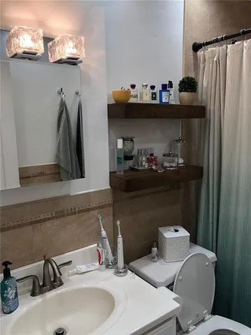 a bathroom with a sink a toilet and a mirror