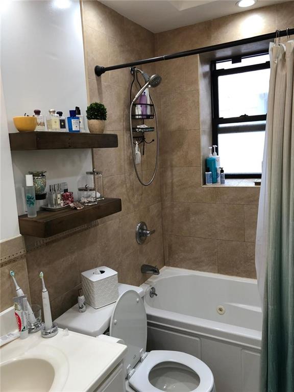 1635 83rd Street Brooklyn, NY 11214 - Photo 9 of 9 a bathroom with a toilet a sink and bathtub