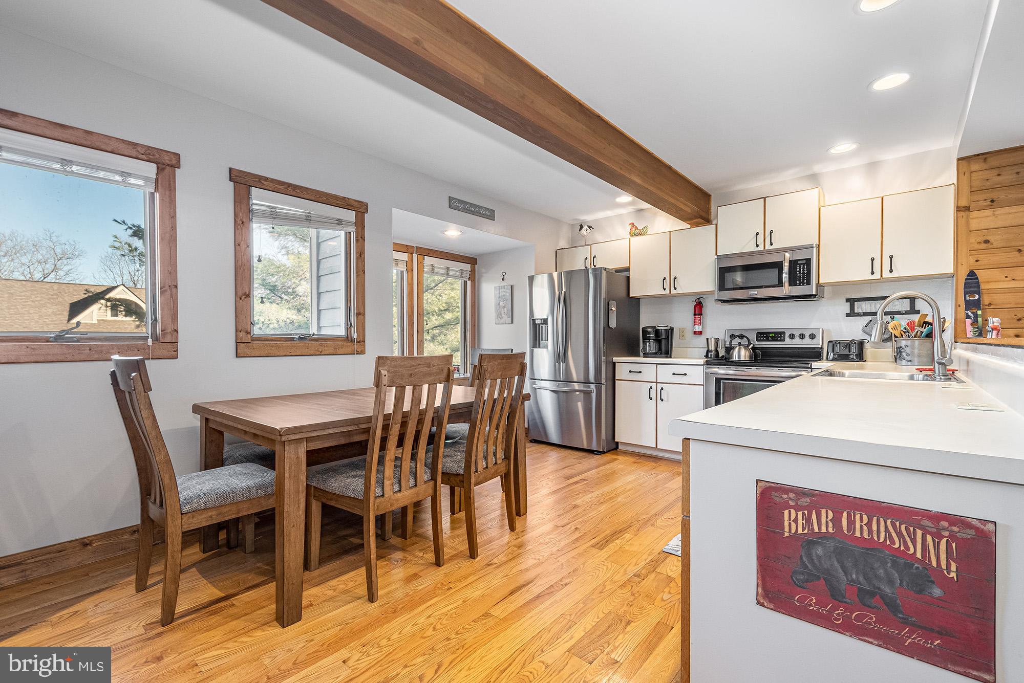 12 Winding Way, Unit 18A McHenry, MD 21541 - Photo 4 of 35 a kitchen with stainless steel appliances granite countertop a stove a refrigerator a kitchen island and chairs with wooden floor