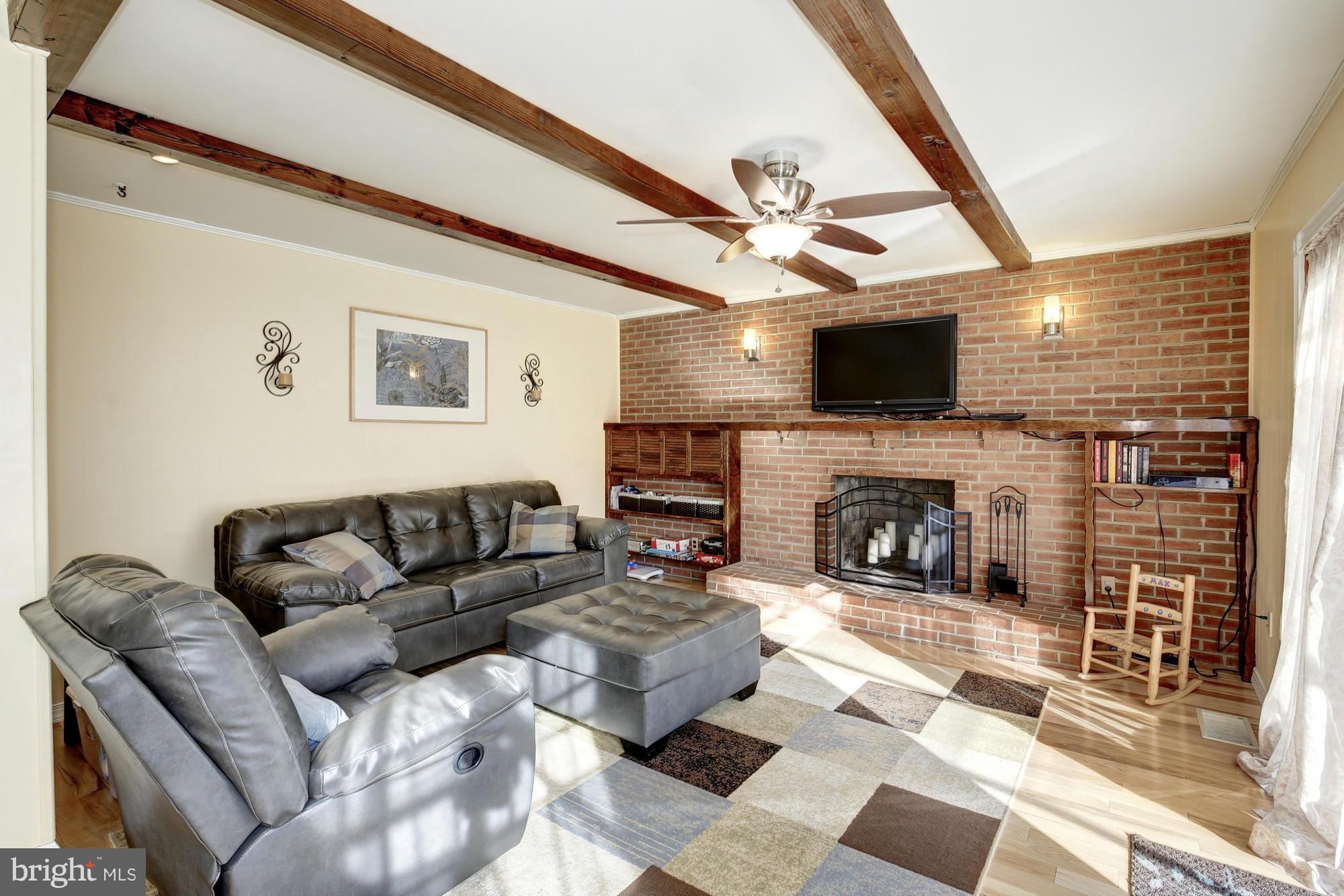 6505 Darwin Road Laurel, MD 20707 - Photo 11 of 30 a living room with furniture a flat screen tv and a fireplace