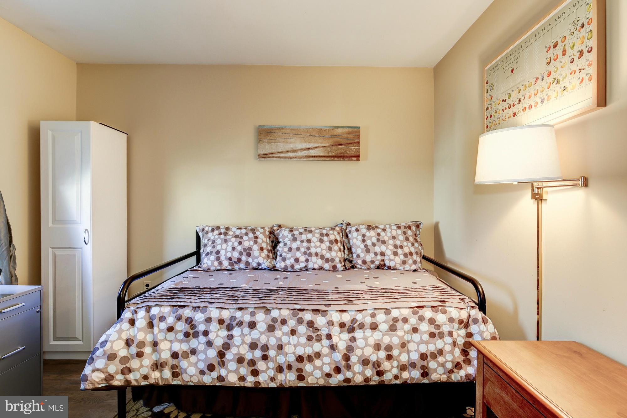 6505 Darwin Road Laurel, MD 20707 - Photo 14 of 30 a large bed sitting in a bedroom next to a lamp