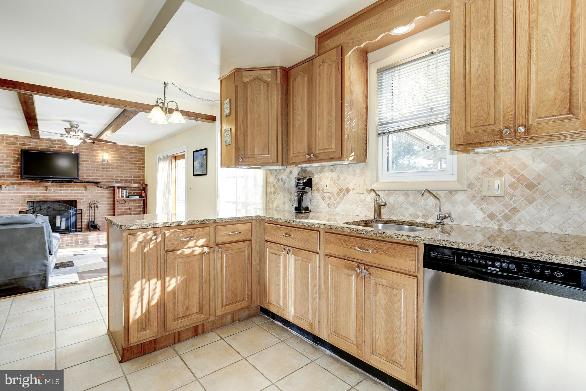 6505 Darwin Road Laurel, MD 20707 - Photo 7 of 30 a kitchen with granite countertop a sink window and cabinets
