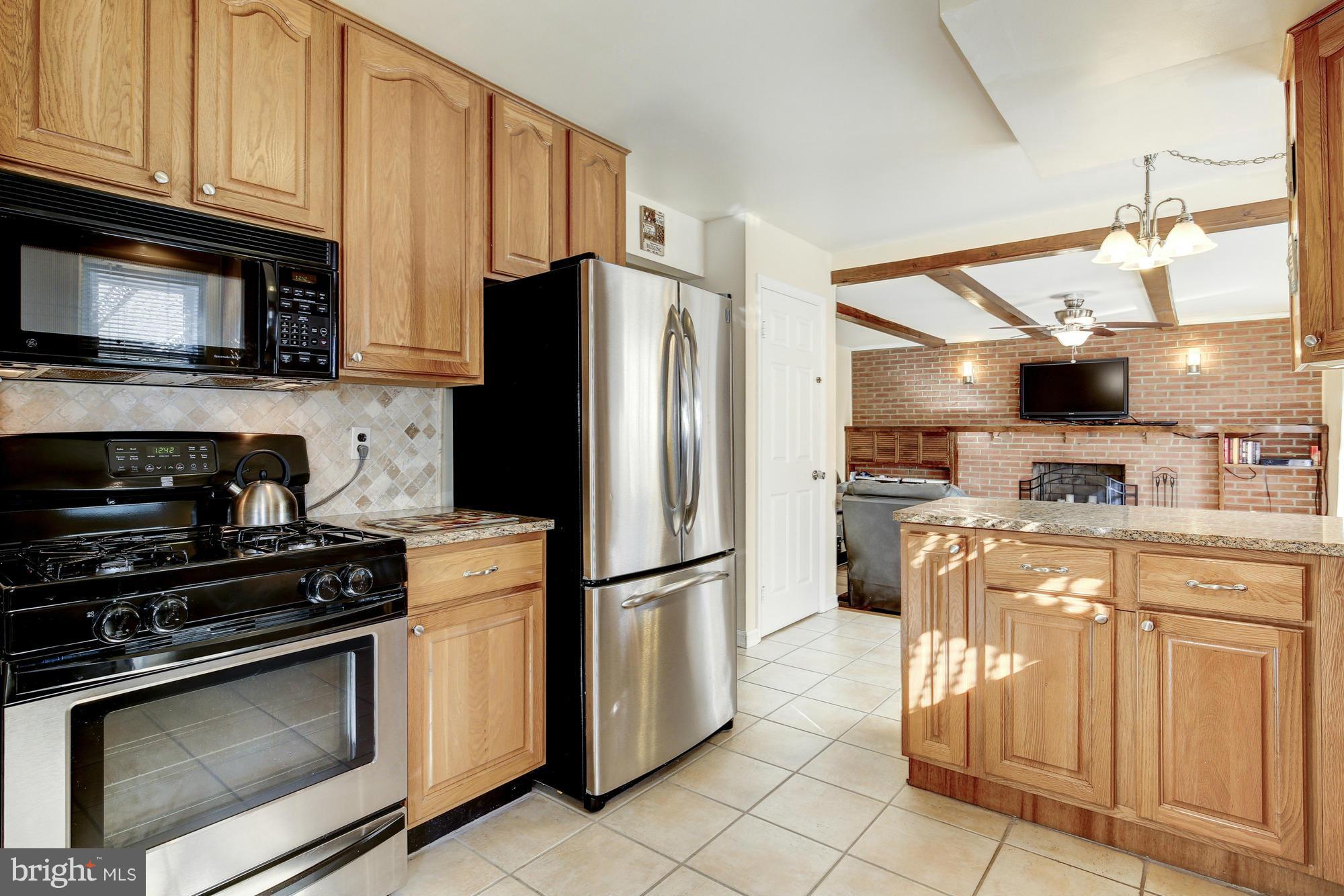 6505 Darwin Road Laurel, MD 20707 - Photo 8 of 30 a kitchen with stainless steel appliances granite countertop a refrigerator stove and sink