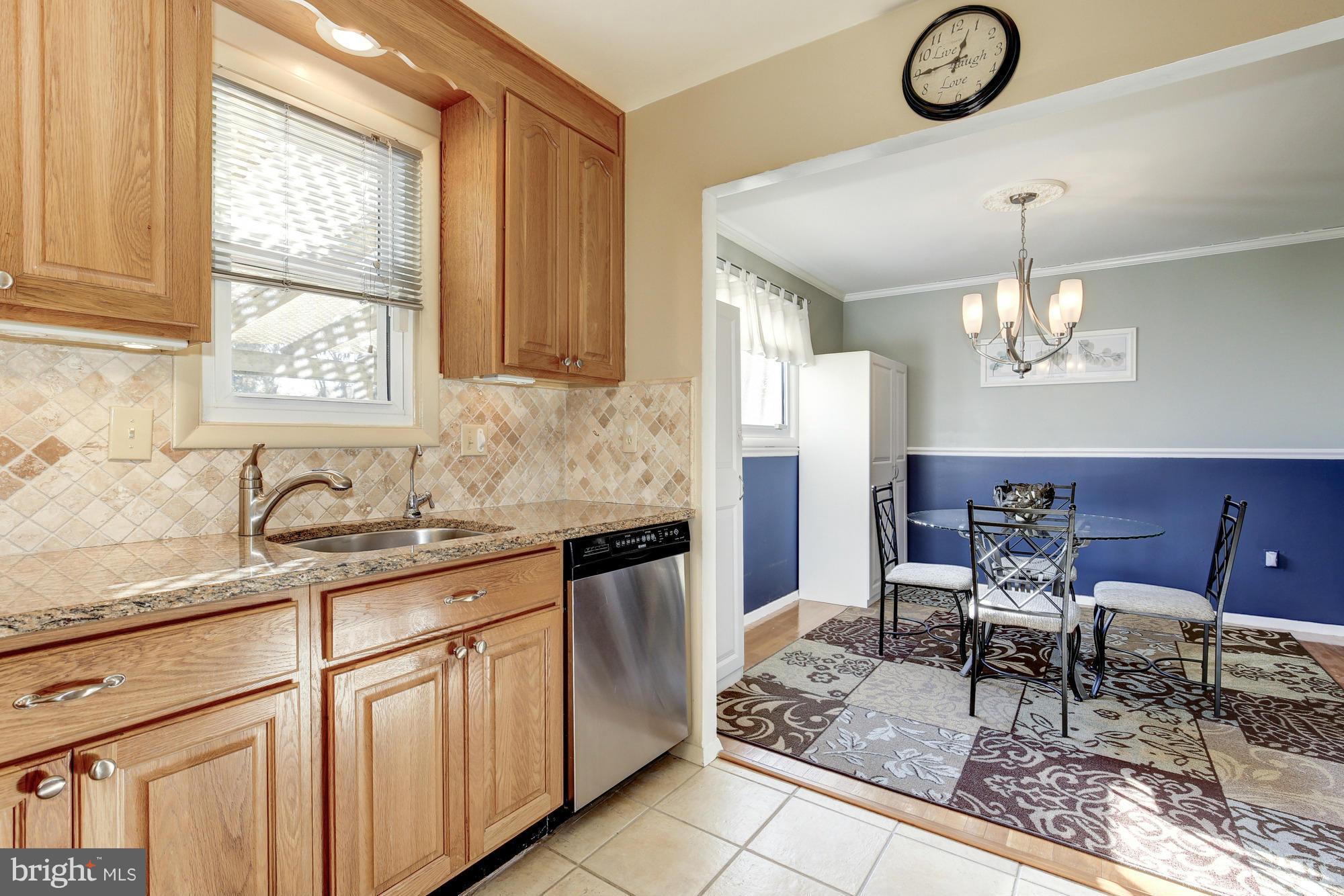 6505 Darwin Road Laurel, MD 20707 - Photo 9 of 30 a kitchen with granite countertop cabinets a dining table and chairs