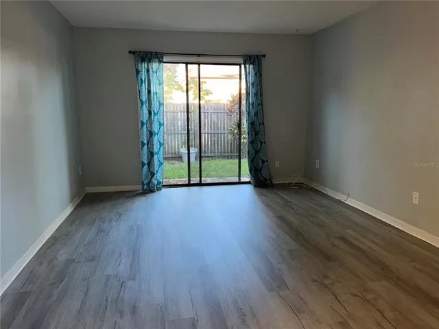 a view of room with window and wooden floor