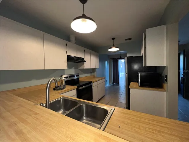 a kitchen with stainless steel appliances granite countertop a sink a stove and a refrigerator