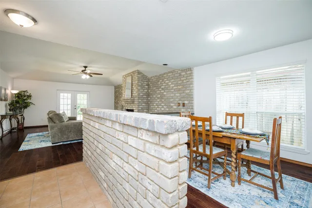 a living room with furniture a dining table and chairs with wooden floor