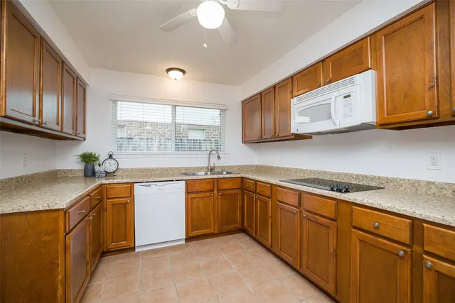 a kitchen with stainless steel appliances granite countertop a sink dishwasher stove and cabinets with wooden floor