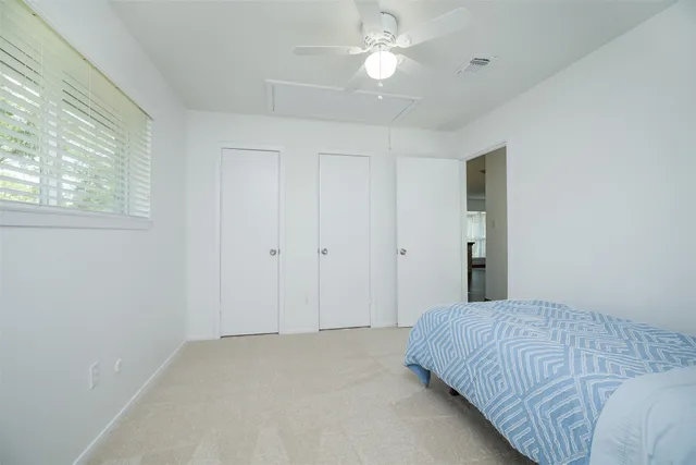 a spacious bedroom with a bed and a window