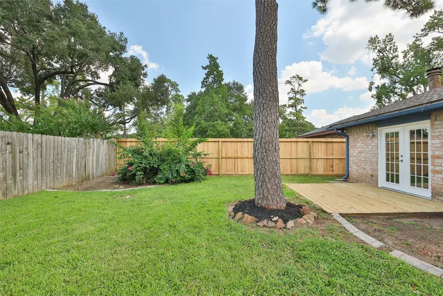 a front view of a house with a yard and tree
