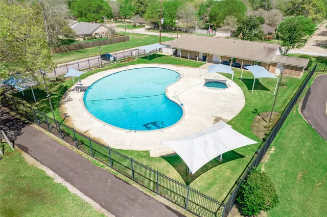 a view of a swimming pool with a yard and plants