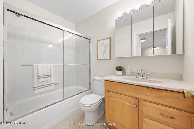 a bathroom with a granite countertop sink mirror vanity and toilet