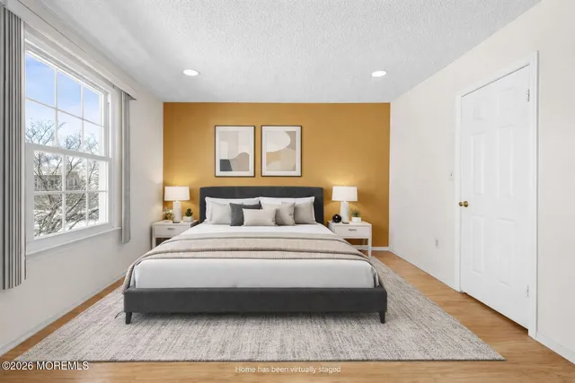 a bedroom with a large bed wooden floor and window