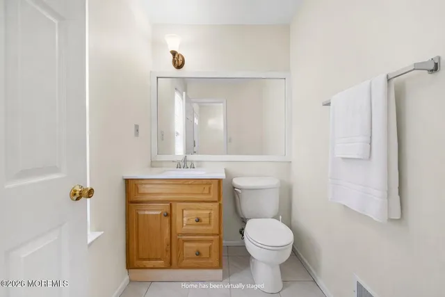 a bathroom with a granite countertop toilet a sink and a mirror