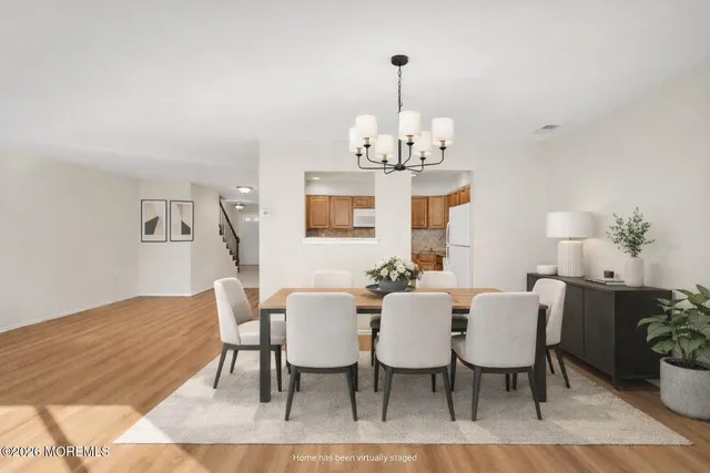 a view of a dining room with furniture a chandelier and wooden floor