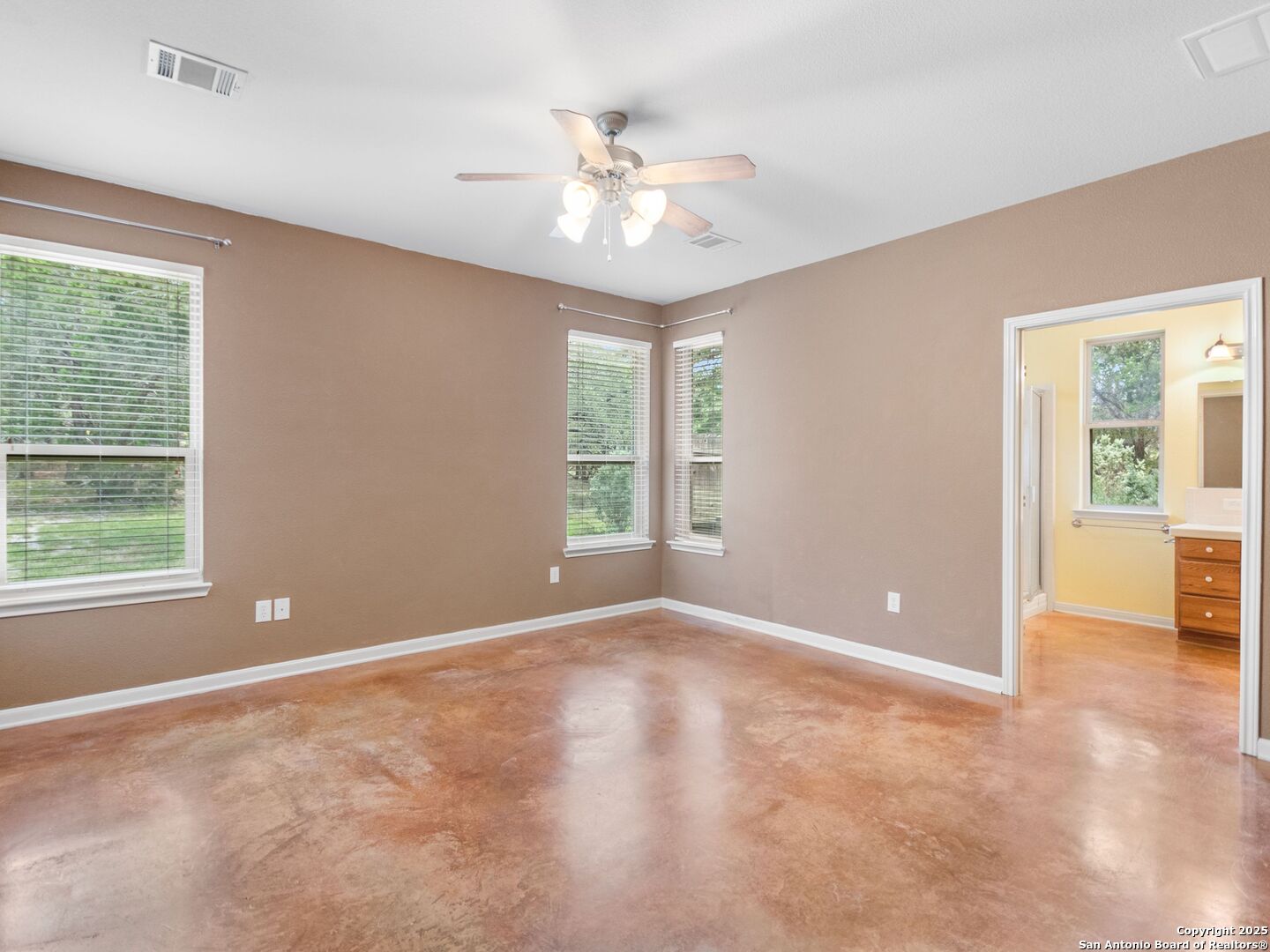 4366 Whartons Dock Road Bandera, TX 78003 - Photo 22 of 80 an empty room with windows and chandelier fan