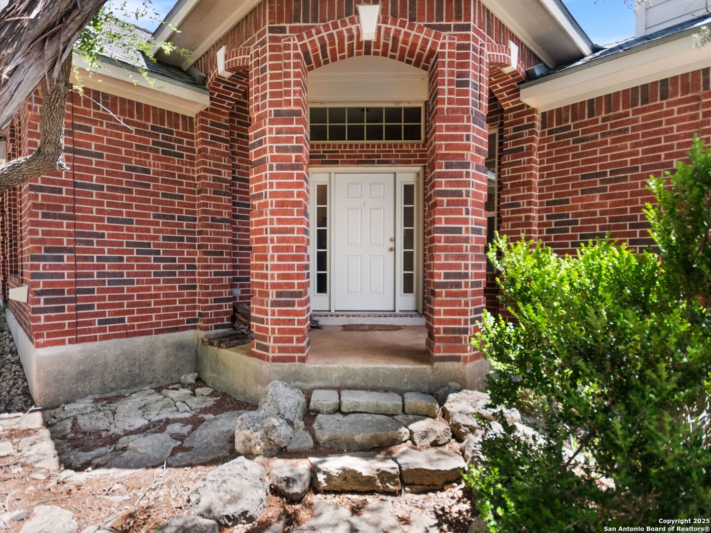 4366 Whartons Dock Road Bandera, TX 78003 - Photo 10 of 80 a view of a brick house with plants and wooden fence