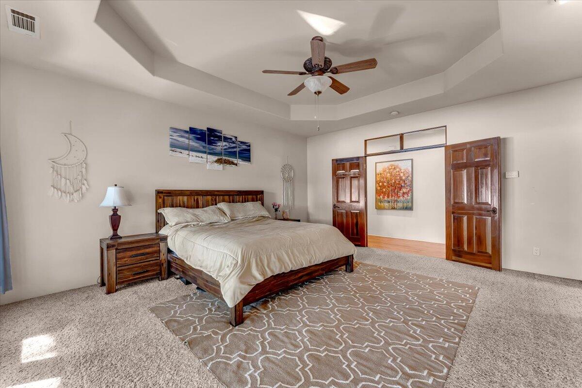 6681 Riverside Drive Redding, CA 96001 - Photo 44 of 124 a spacious bedroom with a bed and a chandelier