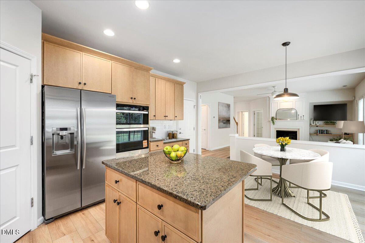 411 Amiable Loop Cary, NC 27519 - Photo 14 of 40 a kitchen with stainless steel appliances granite countertop a sink refrigerator and cabinets