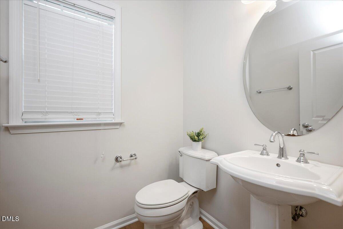 411 Amiable Loop Cary, NC 27519 - Photo 18 of 40 a bathroom with a toilet a sink and mirror