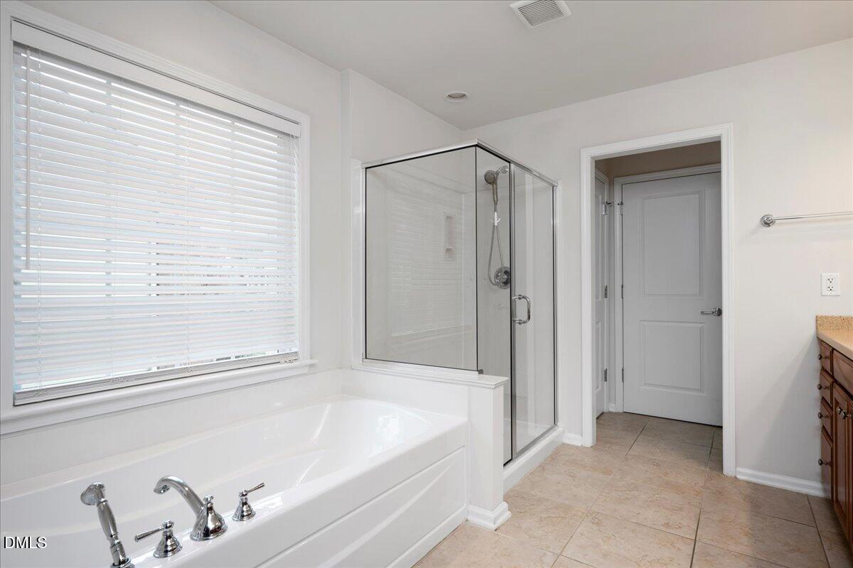 411 Amiable Loop Cary, NC 27519 - Photo 21 of 40 a bathroom with a bathtub and a shower