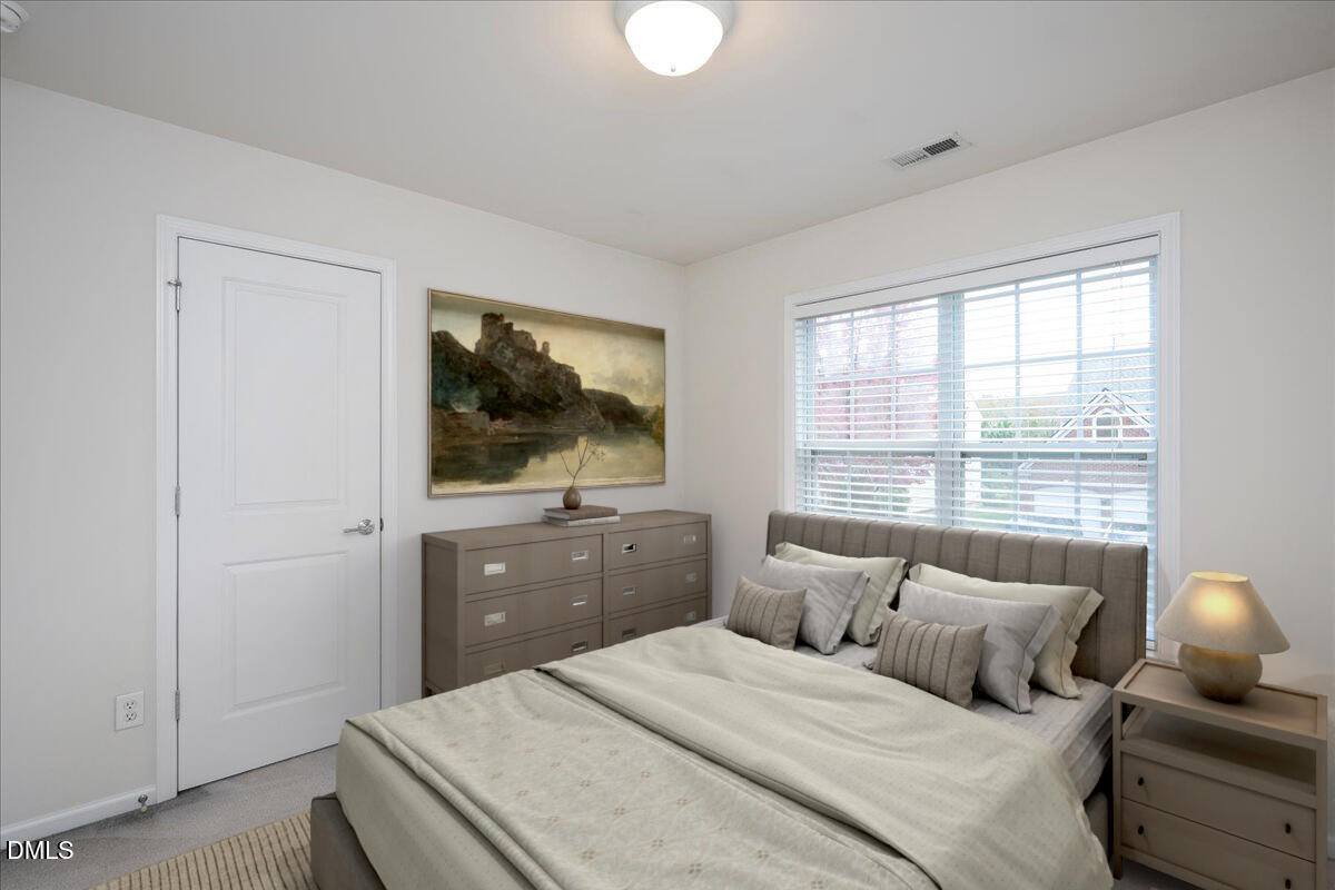 411 Amiable Loop Cary, NC 27519 - Photo 24 of 40 a bedroom with a bed and a flat screen tv