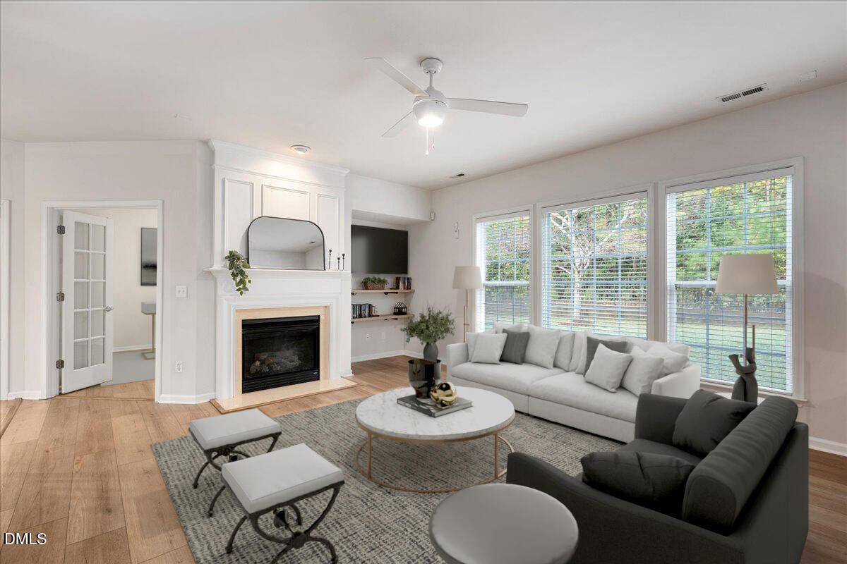 411 Amiable Loop Cary, NC 27519 - Photo 8 of 40 a living room with furniture a fireplace and a large window