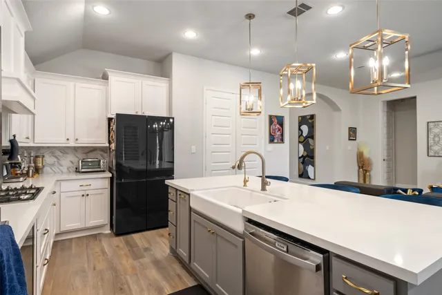 a kitchen with a sink stainless steel appliances a counter space and cabinets