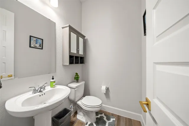 a bathroom with a sink toilet and mirror