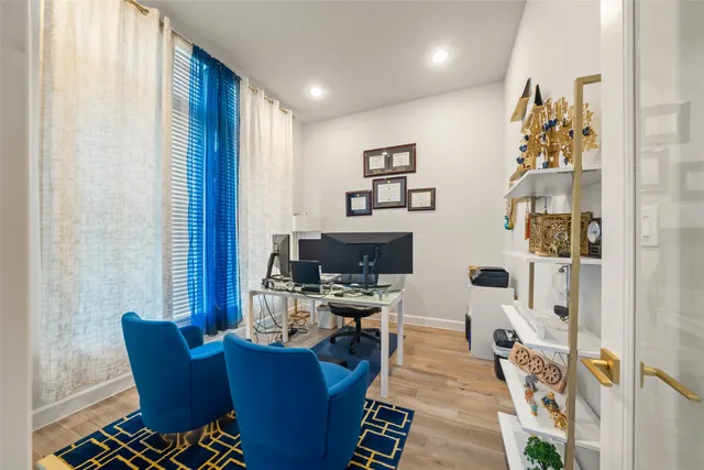 a view of a workspace with furniture and a window