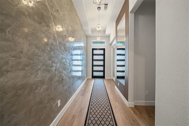 a view of a hallway with wooden floor and staircase