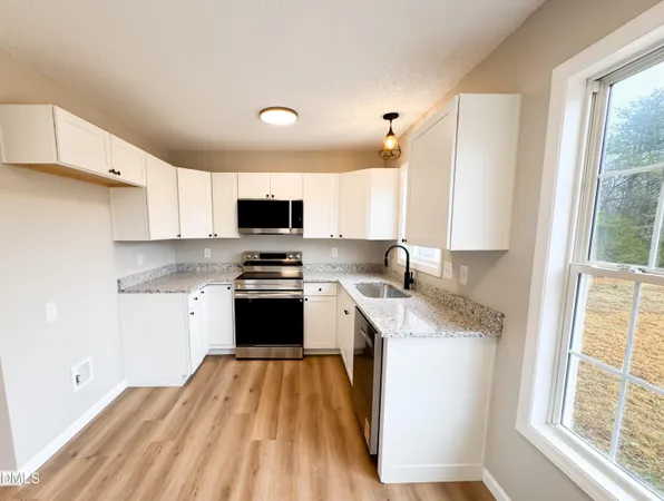 a kitchen with a sink a window and appliances