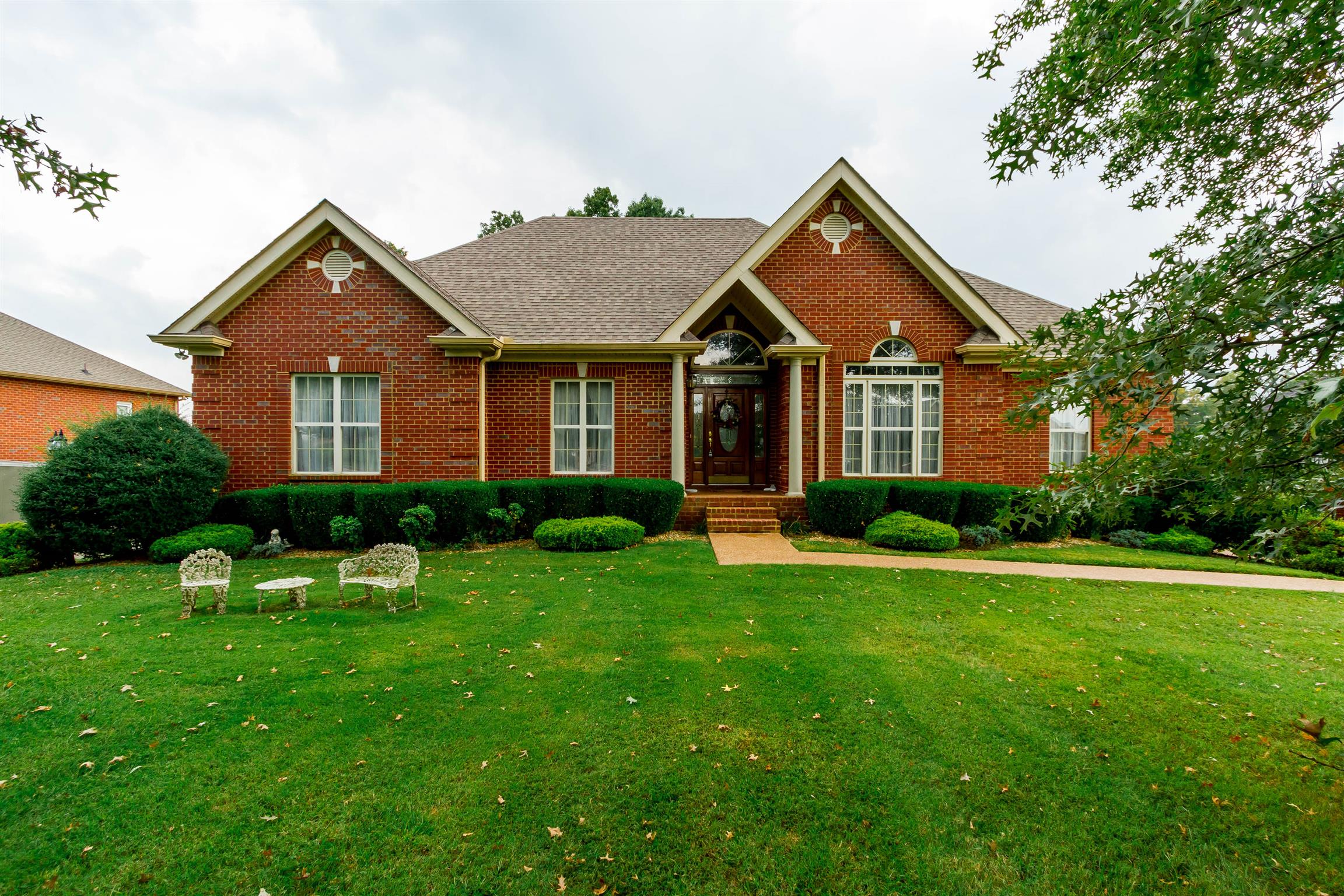 a front view of a house with a yard and trees