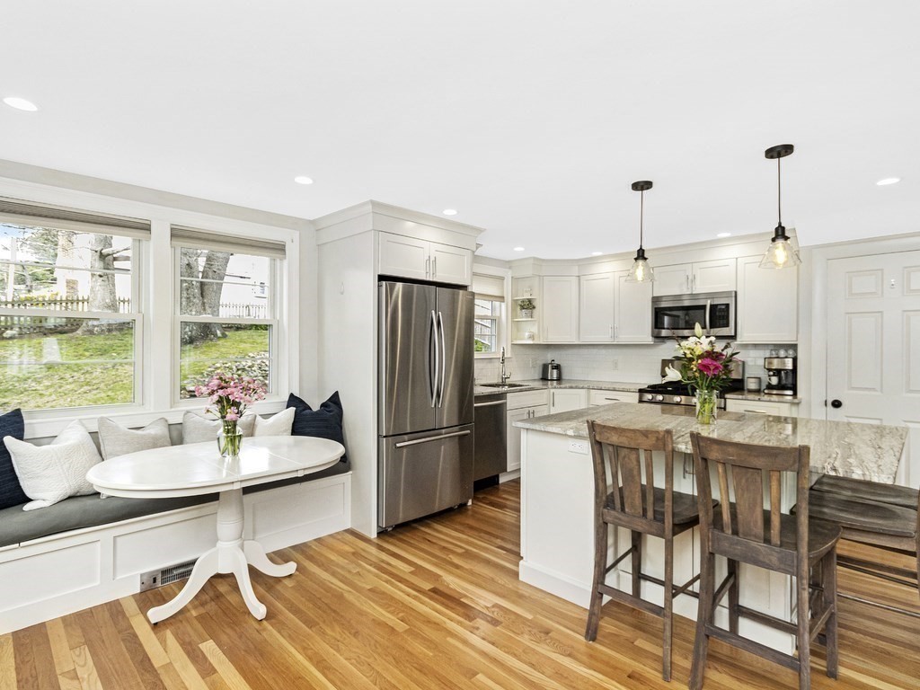 314 Florence Road Waltham, MA 02453 - Photo 8 of 40 a kitchen with stainless steel appliances kitchen island granite countertop a refrigerator a stove a dining table and chairs with wooden floor