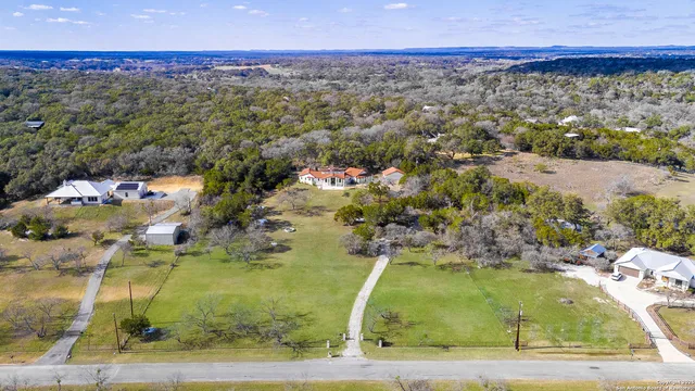 an aerial view of residential houses with outdoor space and trees