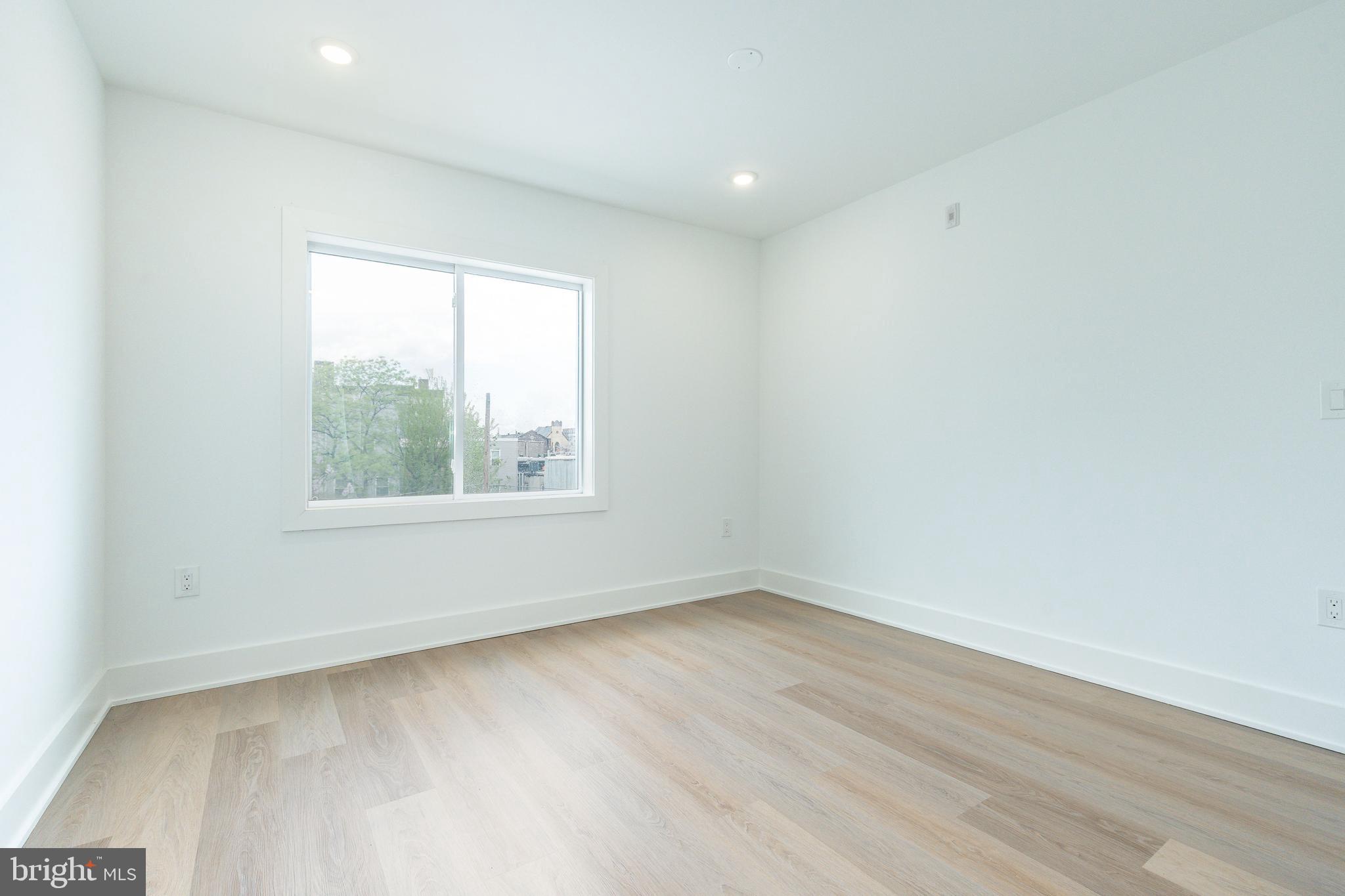 2252 North Front Street, Unit 2 Philadelphia, PA 19133 - Photo 2 of 15 an empty room with wooden floor and windows