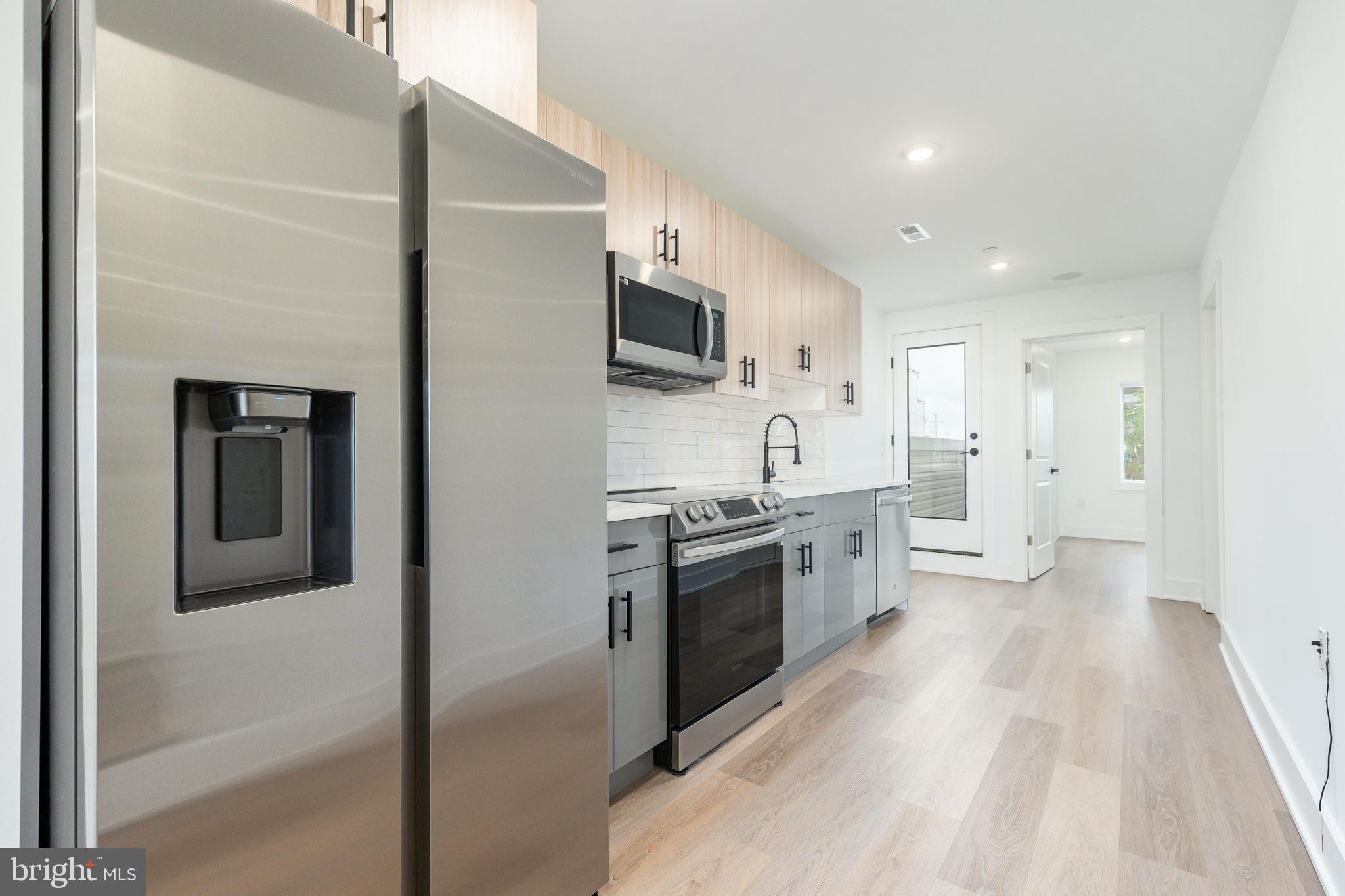 2252 North Front Street, Unit 2 Philadelphia, PA 19133 - Photo 4 of 15 a large kitchen with a stove a sink and a refrigerator