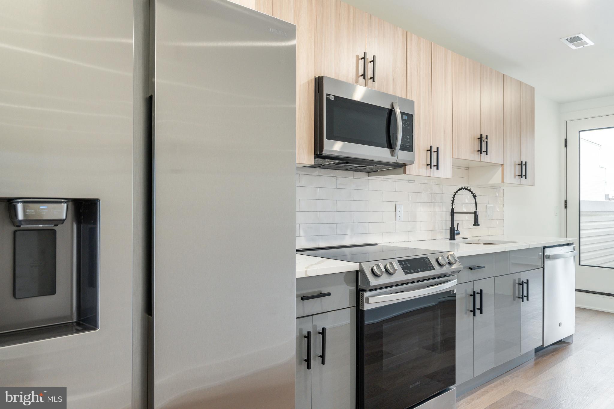 2252 North Front Street, Unit 2 Philadelphia, PA 19133 - Photo 5 of 15 a kitchen with stainless steel appliances granite countertop white cabinets a microwave oven and a sink
