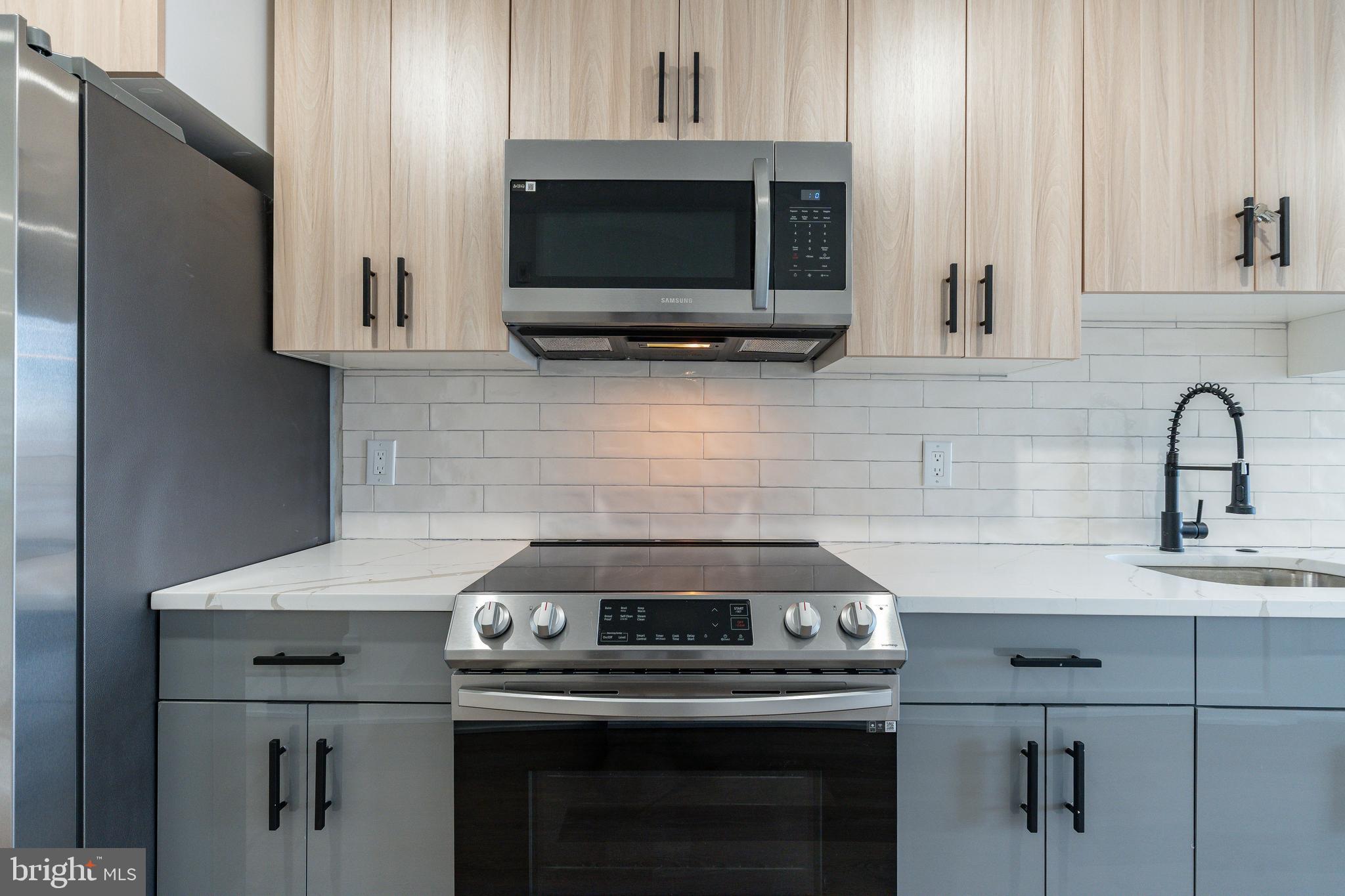 2252 North Front Street, Unit 2 Philadelphia, PA 19133 - Photo 6 of 15 a kitchen with stainless steel appliances a stove a microwave and sink